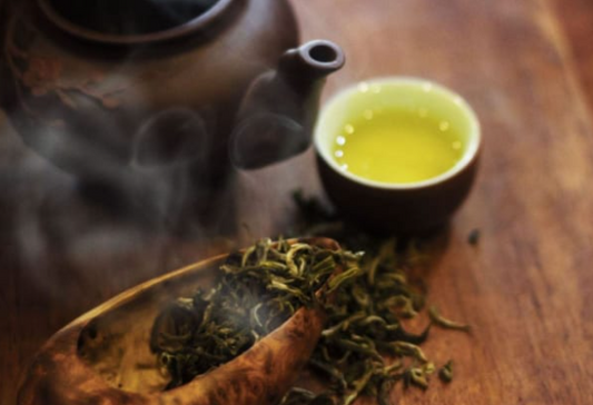 A cup of clear shiny yellow Ancient Shan Tuyet Premium Tea from Hà Giang Vietnam with the purest air and organic natural tea. The trees are over hundred of years old.